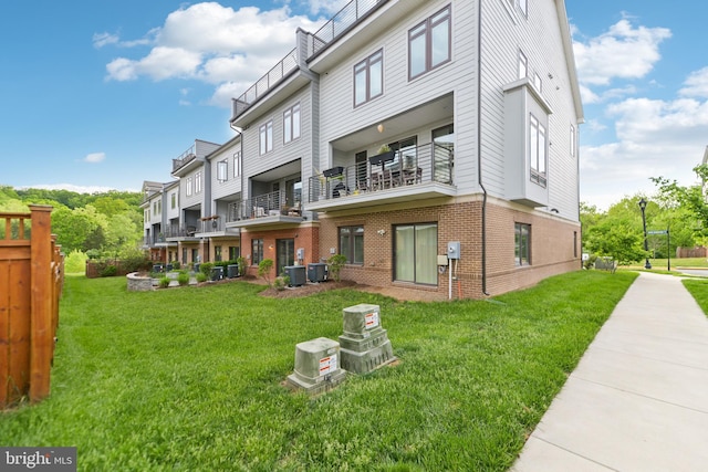 1702 River Sandstone Ter SE, Leesburg, VA 20175 - rear view of property with brick siding, cooling unit, and a lawn