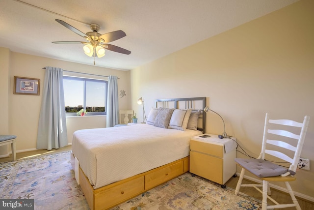 bedroom with a ceiling fan and baseboards