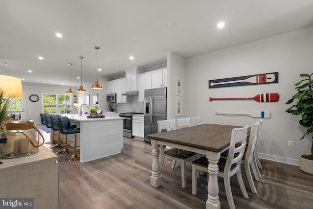 dining room with recessed lighting, baseboards, and wood finished floors