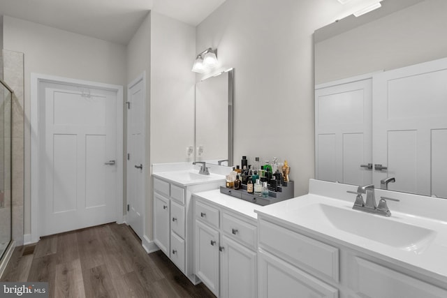 bathroom featuring vanity, a stall shower, and wood finished floors