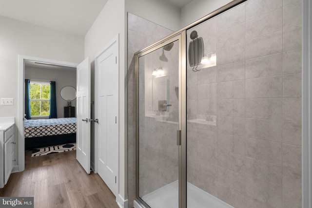 ensuite bathroom with wood finished floors, vanity, ensuite bath, and a shower stall