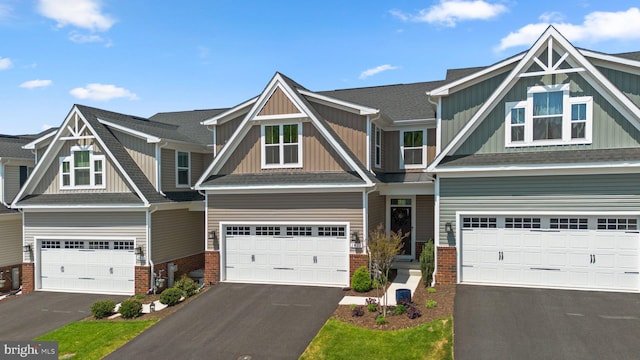 view of front of home with board and batten siding, brick siding, and aphalt driveway