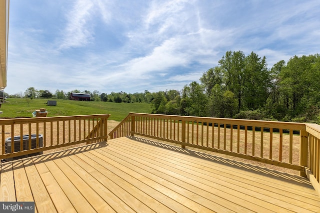 wooden deck with central air condition unit and a yard