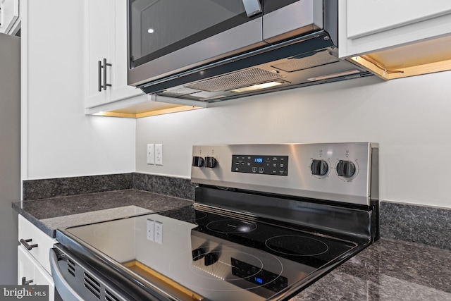 kitchen with white cabinetry, dark stone countertops, and appliances with stainless steel finishes