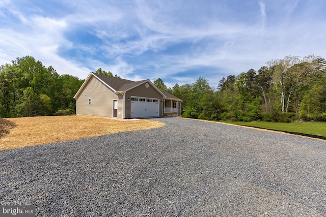 view of property exterior with gravel driveway and a garage