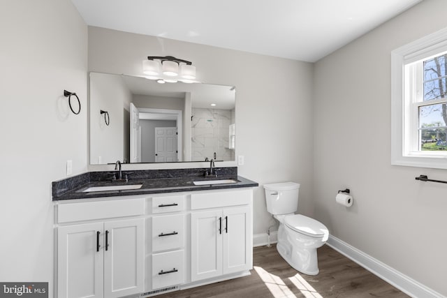 full bathroom featuring wood finished floors, toilet, baseboards, and a sink
