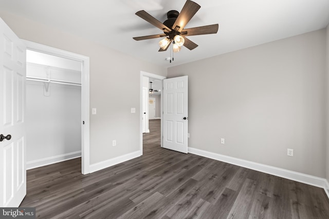 unfurnished bedroom with a closet, a ceiling fan, baseboards, and dark wood-type flooring