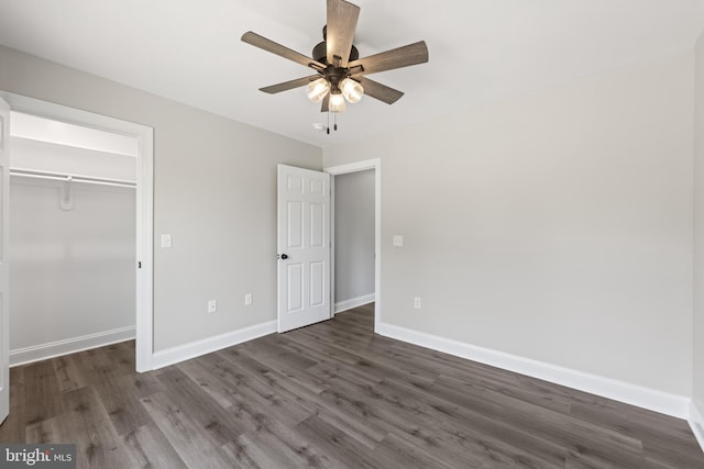unfurnished bedroom featuring a closet, a ceiling fan, baseboards, and dark wood-type flooring