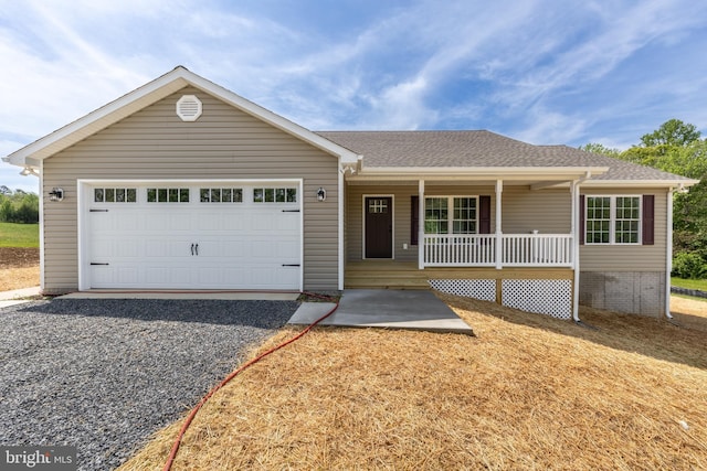 single story home with covered porch, a shingled roof, driveway, and an attached garage