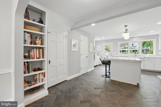 kitchen featuring recessed lighting, white cabinets, a kitchen bar, a center island, and pendant lighting