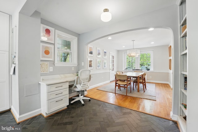office area featuring recessed lighting, arched walkways, built in study area, baseboards, and a notable chandelier