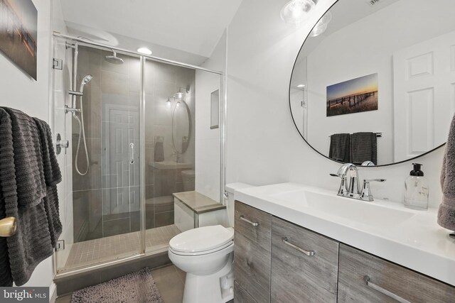 bathroom featuring toilet, a stall shower, tile patterned flooring, and vanity