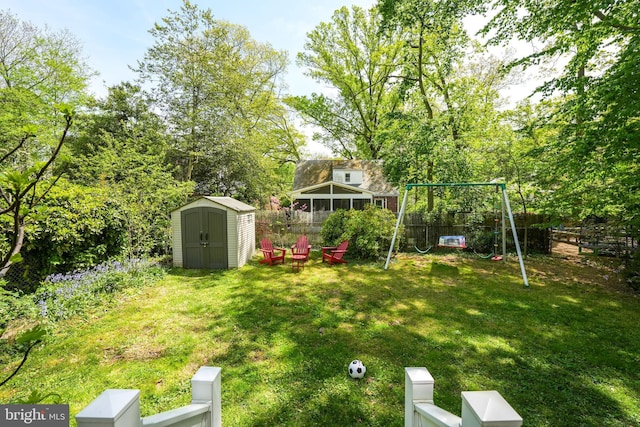 view of yard with a playground, an outbuilding, a shed, and a fenced backyard