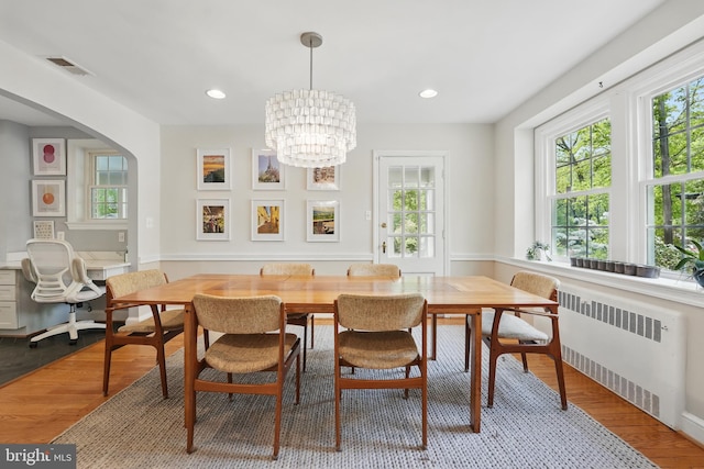 dining space featuring visible vents, an inviting chandelier, recessed lighting, radiator heating unit, and wood finished floors