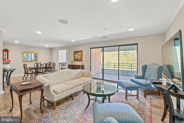 living room featuring visible vents, ornamental molding, recessed lighting, and light wood-style flooring