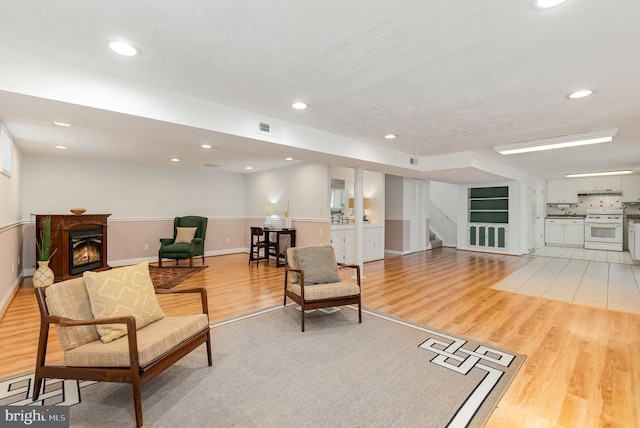 4 Hallbrook Ct, Baltimore, MD 21236 - sitting room with a lit fireplace, visible vents, stairway, baseboards, and light wood-style floors