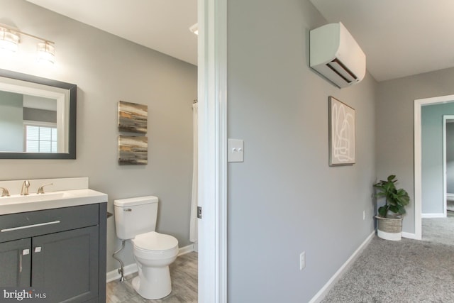 full bathroom featuring a shower with curtain, vanity, toilet, baseboards, and an AC wall unit