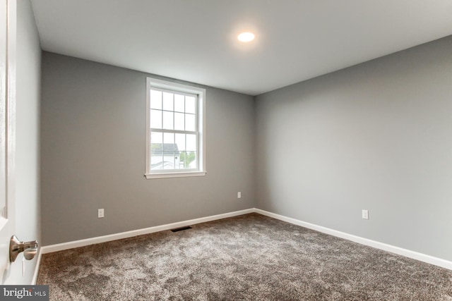 carpeted spare room with baseboards and visible vents