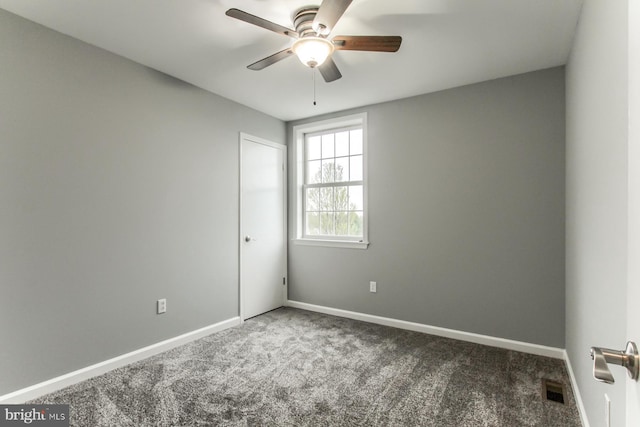 empty room featuring carpet, visible vents, a ceiling fan, and baseboards