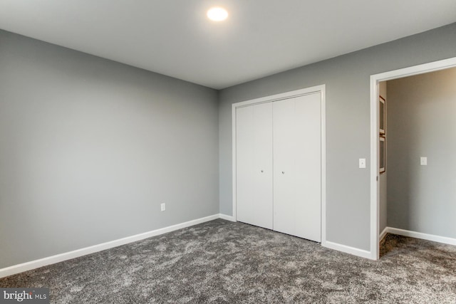 unfurnished bedroom featuring a closet, baseboards, and carpet floors