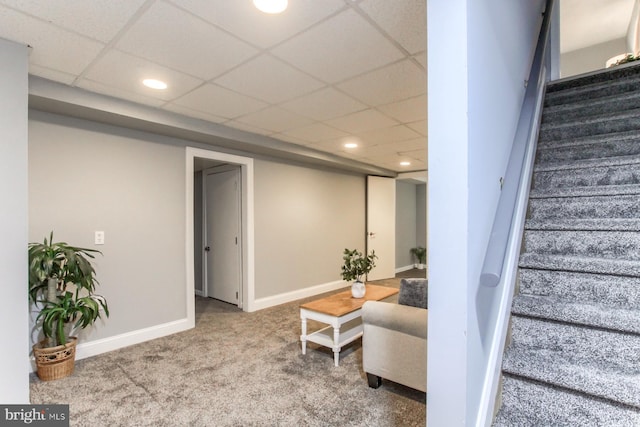 interior space with a drop ceiling, recessed lighting, baseboards, and carpet floors