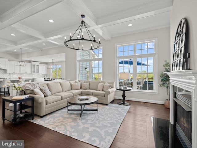 living area featuring a notable chandelier, recessed lighting, dark wood-type flooring, beamed ceiling, and coffered ceiling
