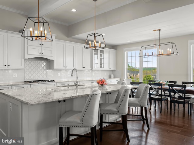 kitchen with crown molding, stainless steel gas stovetop, a notable chandelier, and a sink