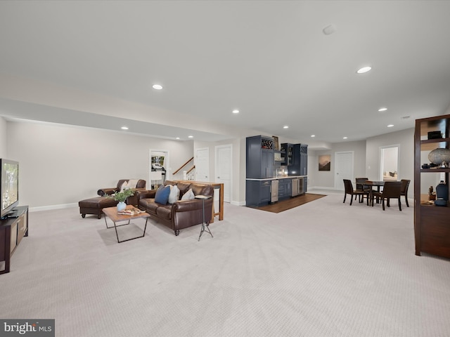 living room with stairs, recessed lighting, light carpet, and a dry bar