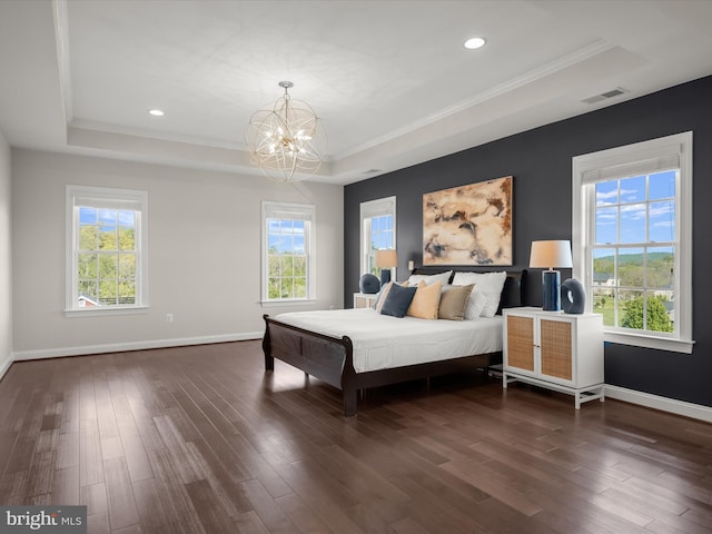 bedroom featuring a notable chandelier, a tray ceiling, dark wood-style floors, and visible vents