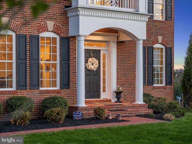 entrance to property featuring brick siding