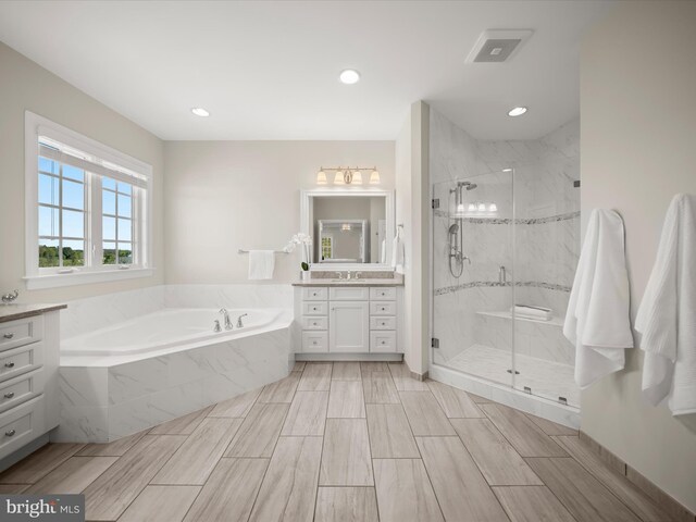 full bath featuring recessed lighting, a marble finish shower, a bath, and vanity