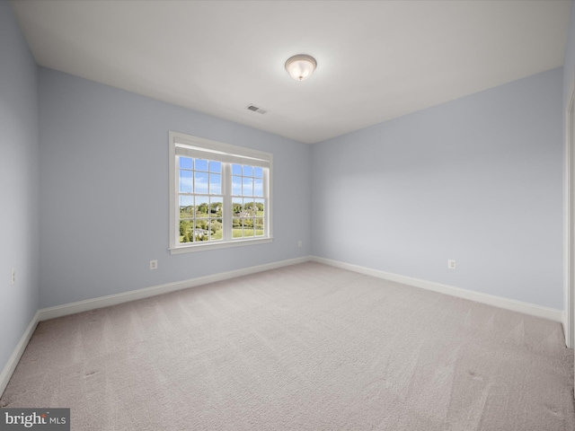 unfurnished room featuring baseboards, visible vents, and light carpet