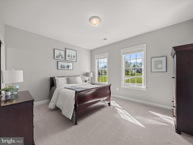 carpeted bedroom with visible vents and baseboards