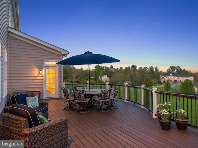 wooden deck with a lawn and outdoor dining space