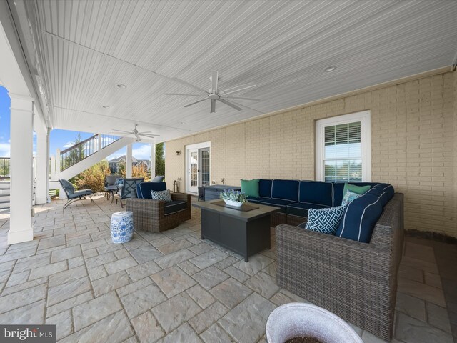 view of patio / terrace featuring a ceiling fan, stairs, and an outdoor living space