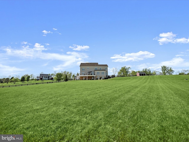 view of yard featuring fence and a rural view