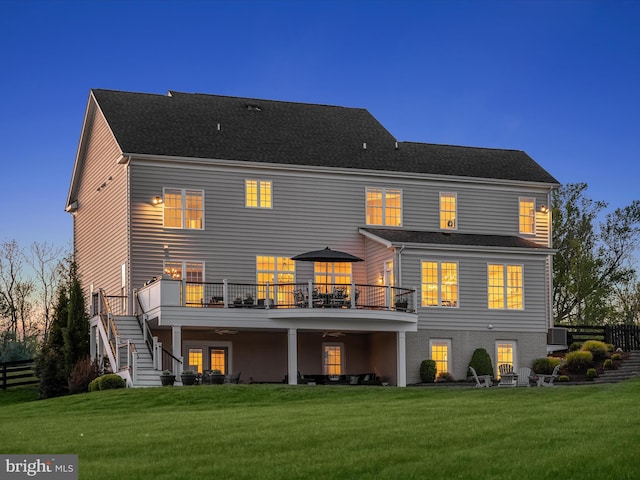 back of property with a lawn, stairs, and a deck