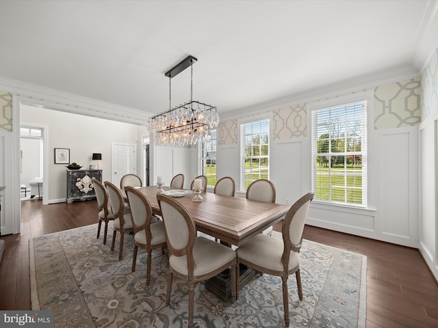 dining space with crown molding, dark wood-style flooring, a chandelier, and wallpapered walls