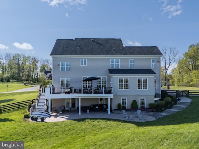 rear view of property with a wooden deck, a patio area, stairway, fence, and a yard