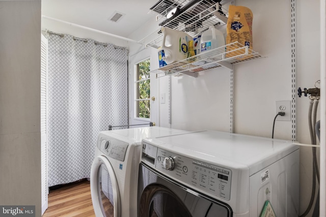 laundry room with light wood-type flooring, visible vents, laundry area, and washer and clothes dryer