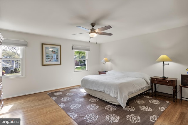 bedroom with wood finished floors, ceiling fan, and baseboards