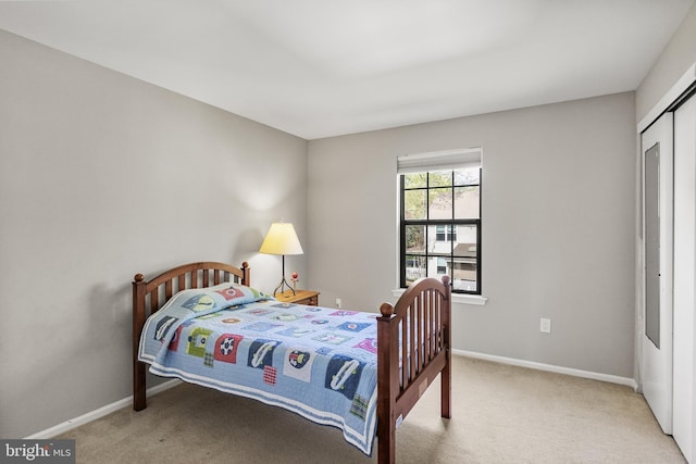 bedroom with a closet, carpet flooring, and baseboards