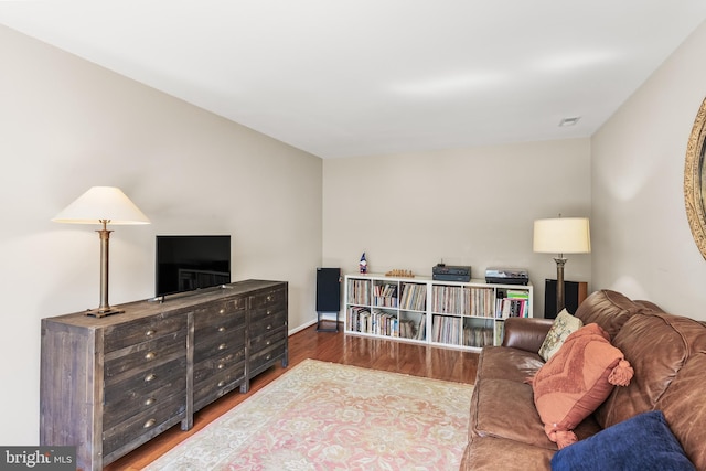 living area with visible vents, wood finished floors, and baseboards