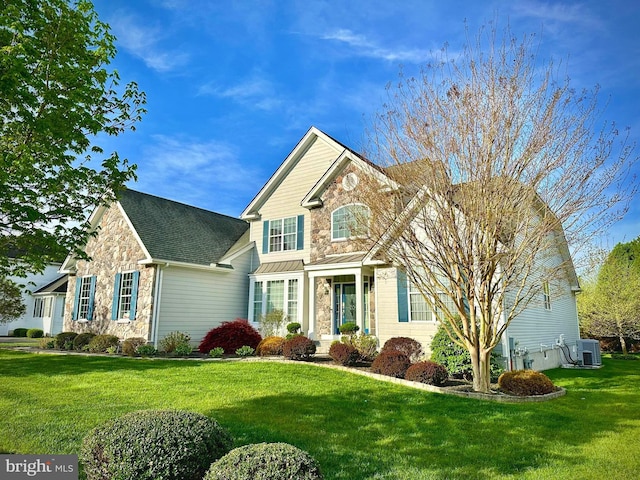 view of front of house with central air condition unit, a front yard, and stone siding