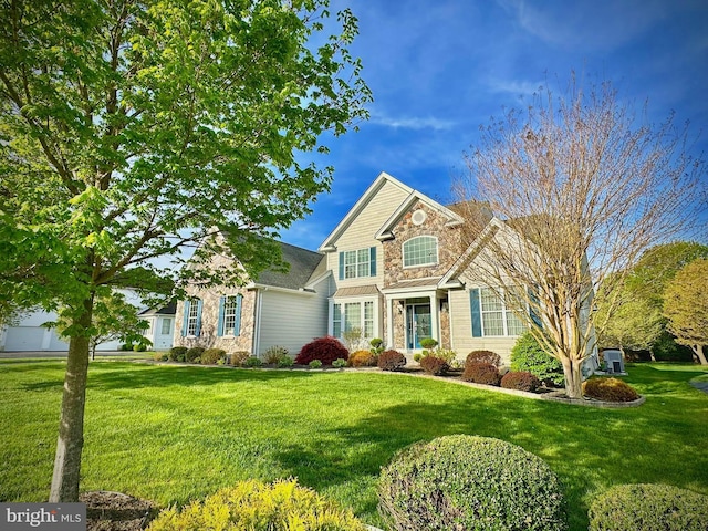 traditional-style home featuring a front yard and stone siding