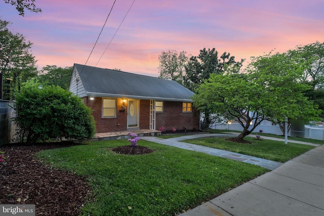 1310 S Columbus St, Arlington, VA 22204 - view of front of home featuring covered porch, a lawn, brick siding, fence, and a shingled roof