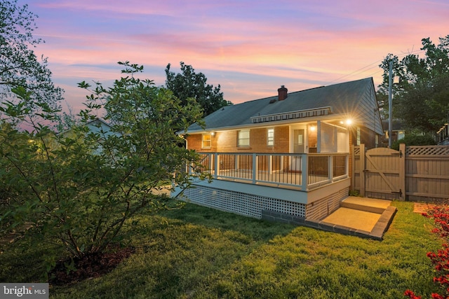 1310 S Columbus St, Arlington, VA 22204 - back of property at dusk featuring a chimney, a lawn, a deck, a gate, and fence
