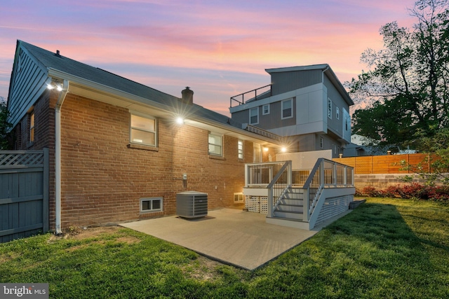 1310 S Columbus St, Arlington, VA 22204 - back of house at dusk featuring a patio area, central air condition unit, brick siding, fence, and a yard