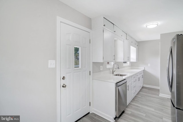 1310 S Columbus St, Arlington, VA 22204 - kitchen with a sink, light wood-style floors, light countertops, stainless steel appliances, and white cabinetry