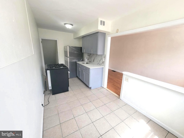 7107 Oakland St, Philadelphia, PA 19149 - kitchen featuring range with gas cooktop, visible vents, gray cabinetry, and a sink